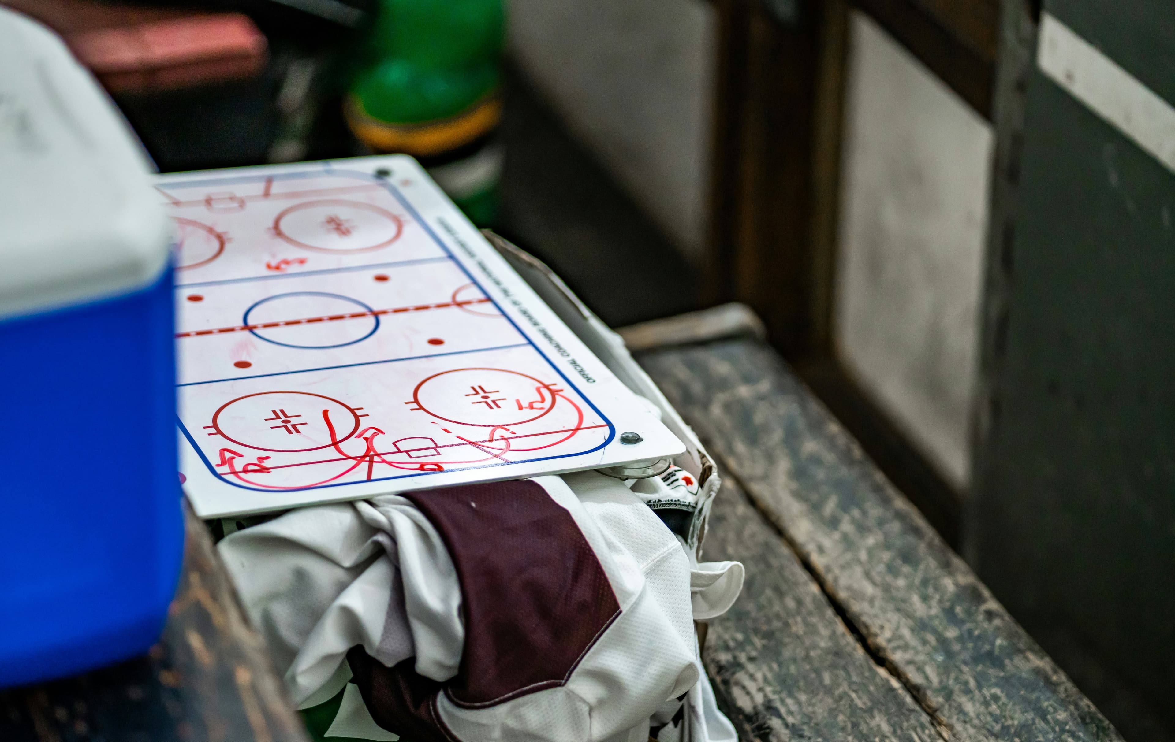 A clipboard of hockey breakout plays beside a rink diagram
